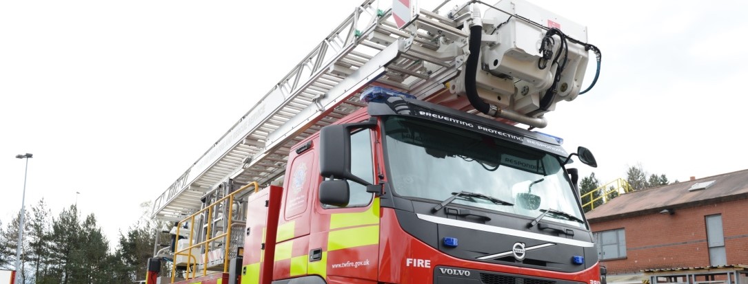 Photograph of a fire engine with aerial ladder equipment on top