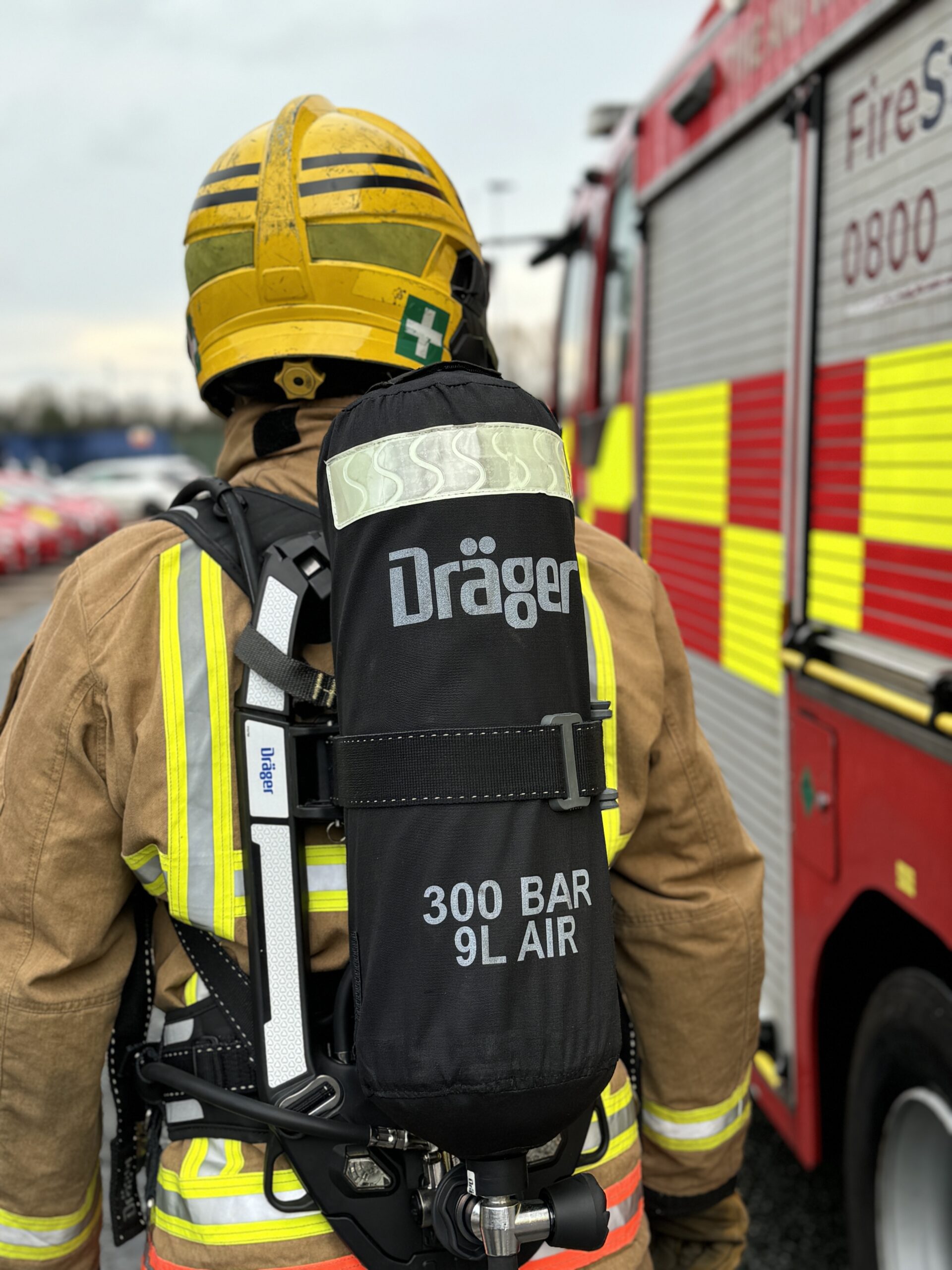 Photograph of the back of a firefighter, carrying breathing apparatus