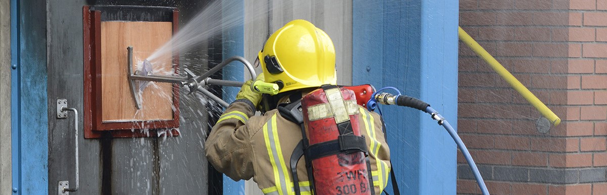 Photograph of a firefighter using the Cobra Extinguishing System
