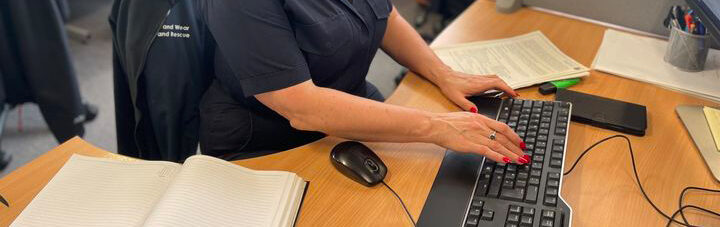 Photograph of a member of staff sitting at their desk