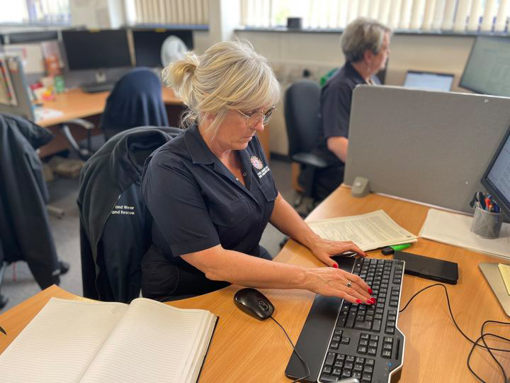 Photograph of a member of staff sitting at their desk