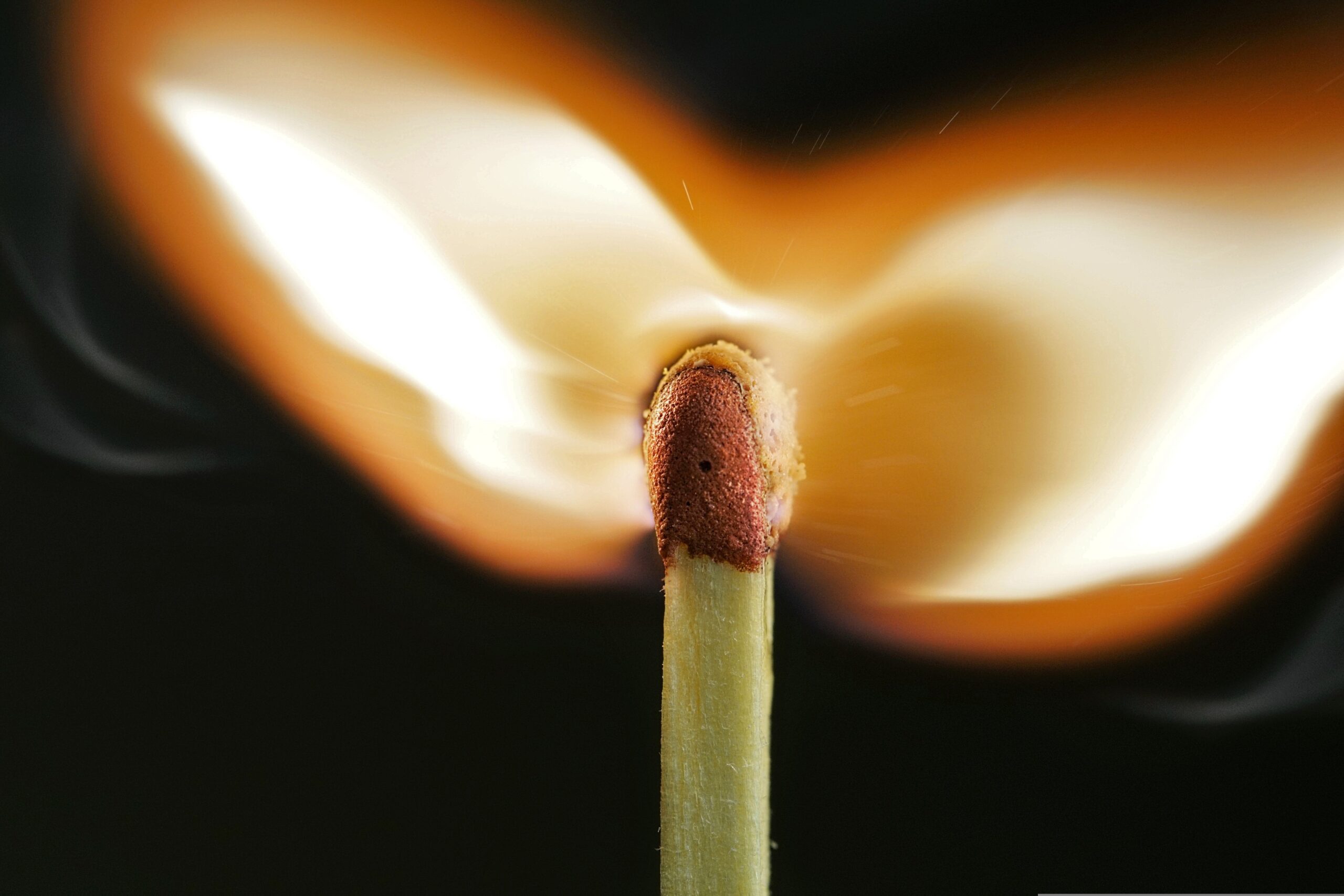A close up image of a wooden match a light.
