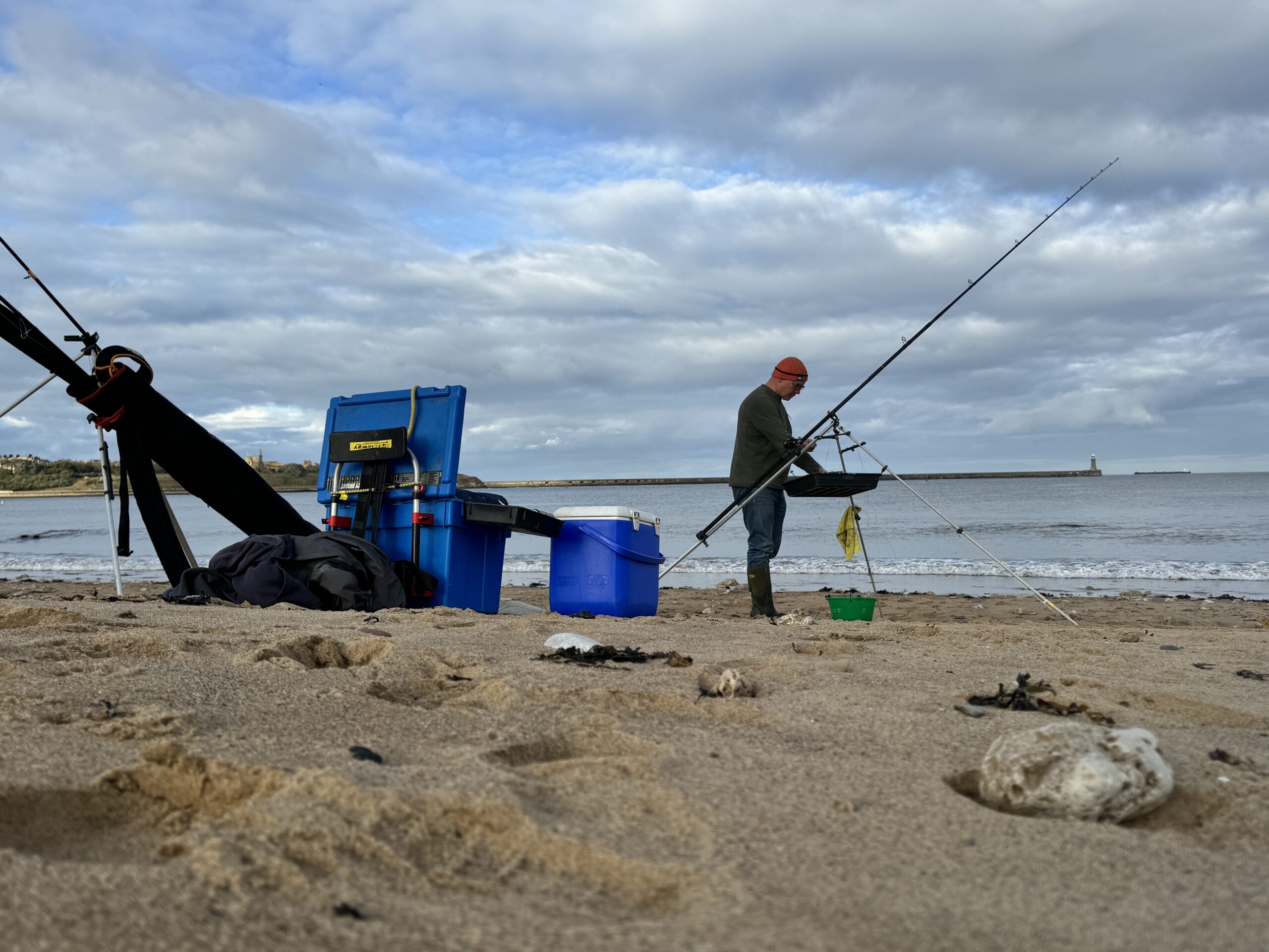 Photograph of a person fishing on the beach