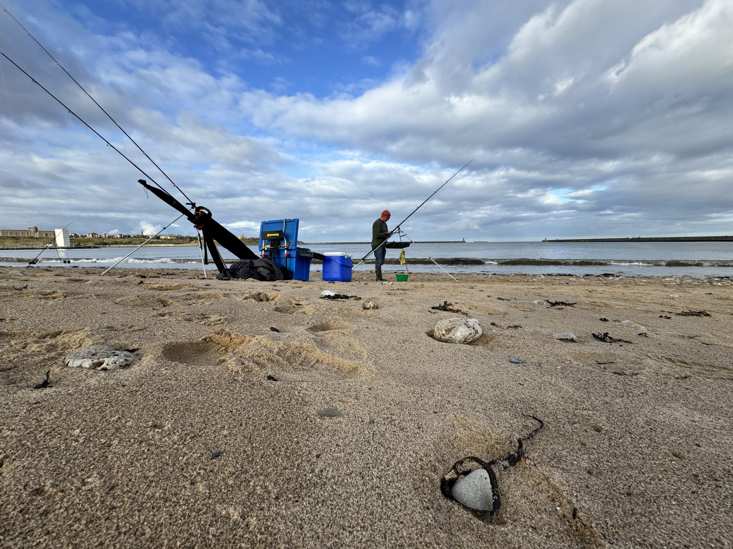 Photograph of a person fishing on the beach