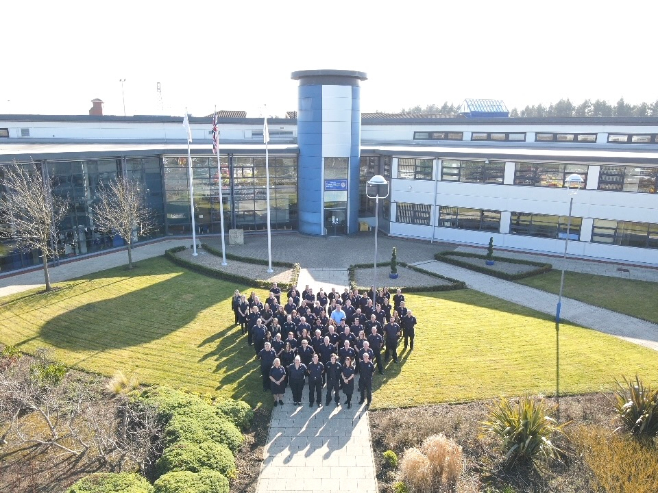 Photograph of approximately fifty staff members standing outside Tyne and Wear Fire and Rescue Service headquarters