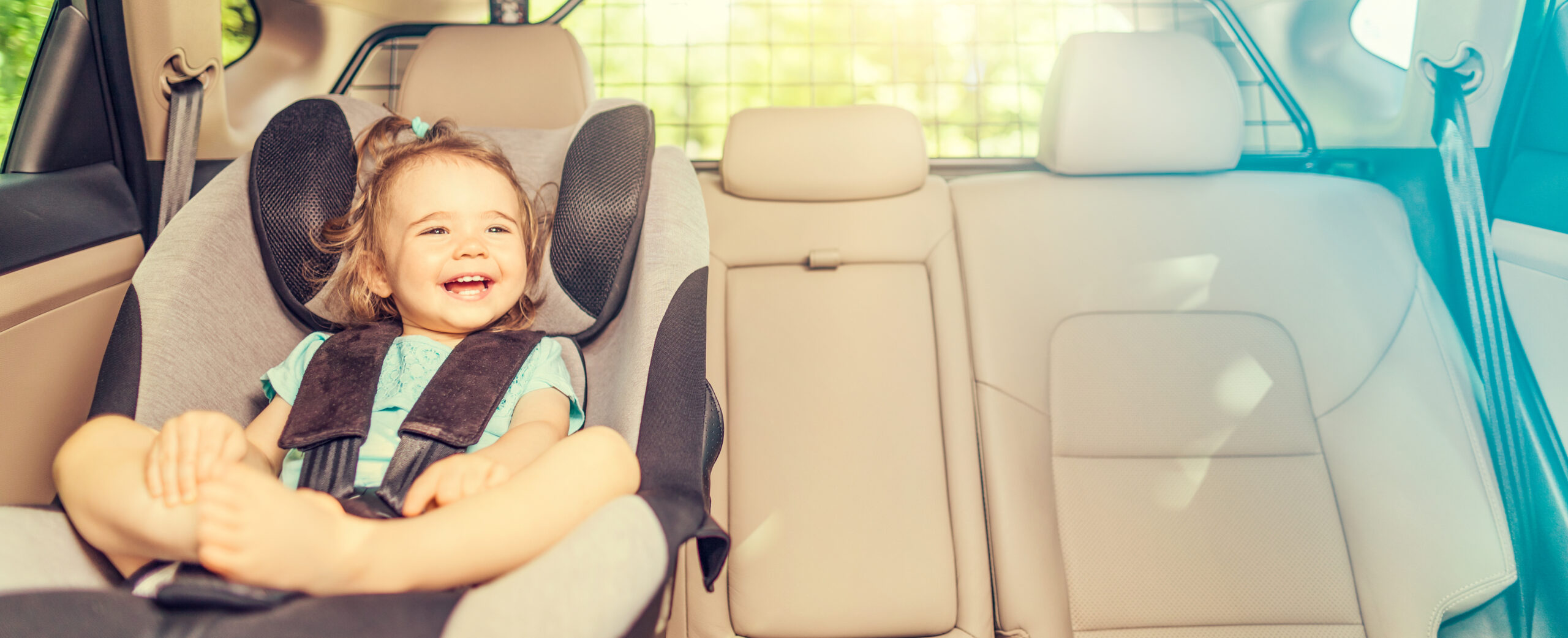 Smiling baby sat in car seat.