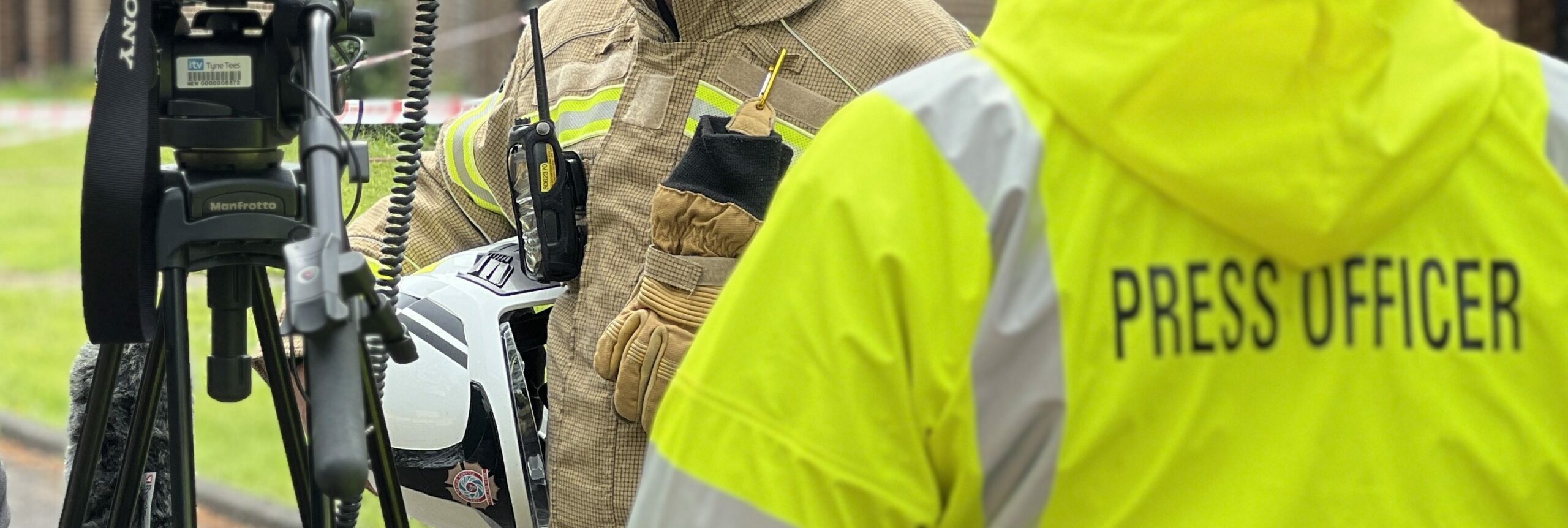 Photograph of a Fire Officer being interviewed by a press officer with camera crew